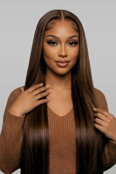 Woman with long brown hair wearing a brown sweater against a gray background
