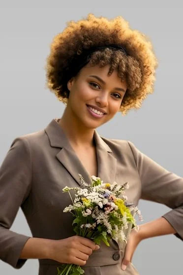 Woman in a brown suit holding flowers against a gray background