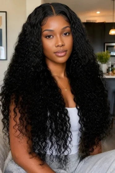 30"-40" Curly HD Lace Front Deep Wave Wig - woman with long voluminous black kinky curly hair, white tank top, indoor setting