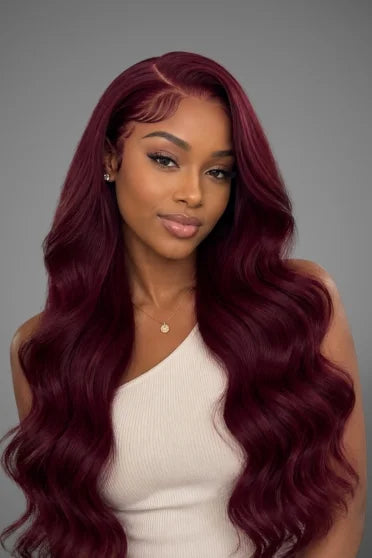 99J Burgundy Body Wave HD Lace Frontal Wig 220% Density - woman with long wavy deep burgundy hair wearing white ribbed top