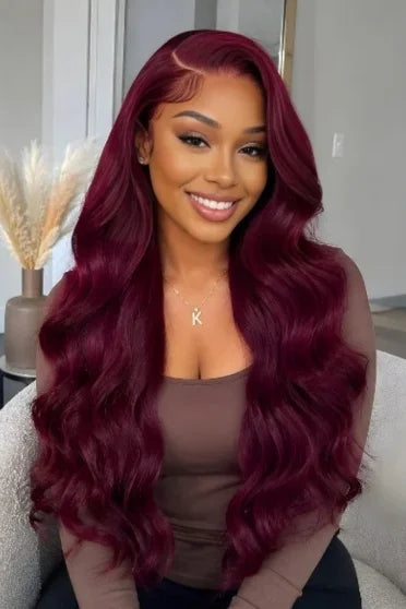 99J Burgundy Body Wave HD Lace Frontal Wig 220% Density - woman with long wavy deep burgundy hair wearing brown top